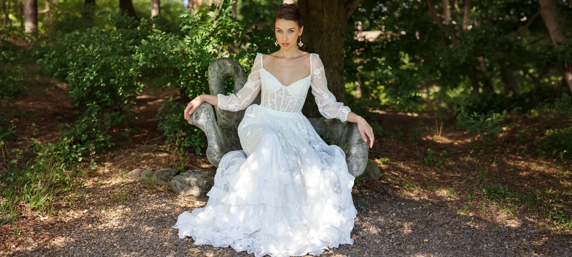 Model wearing a bridal dress on the forest.