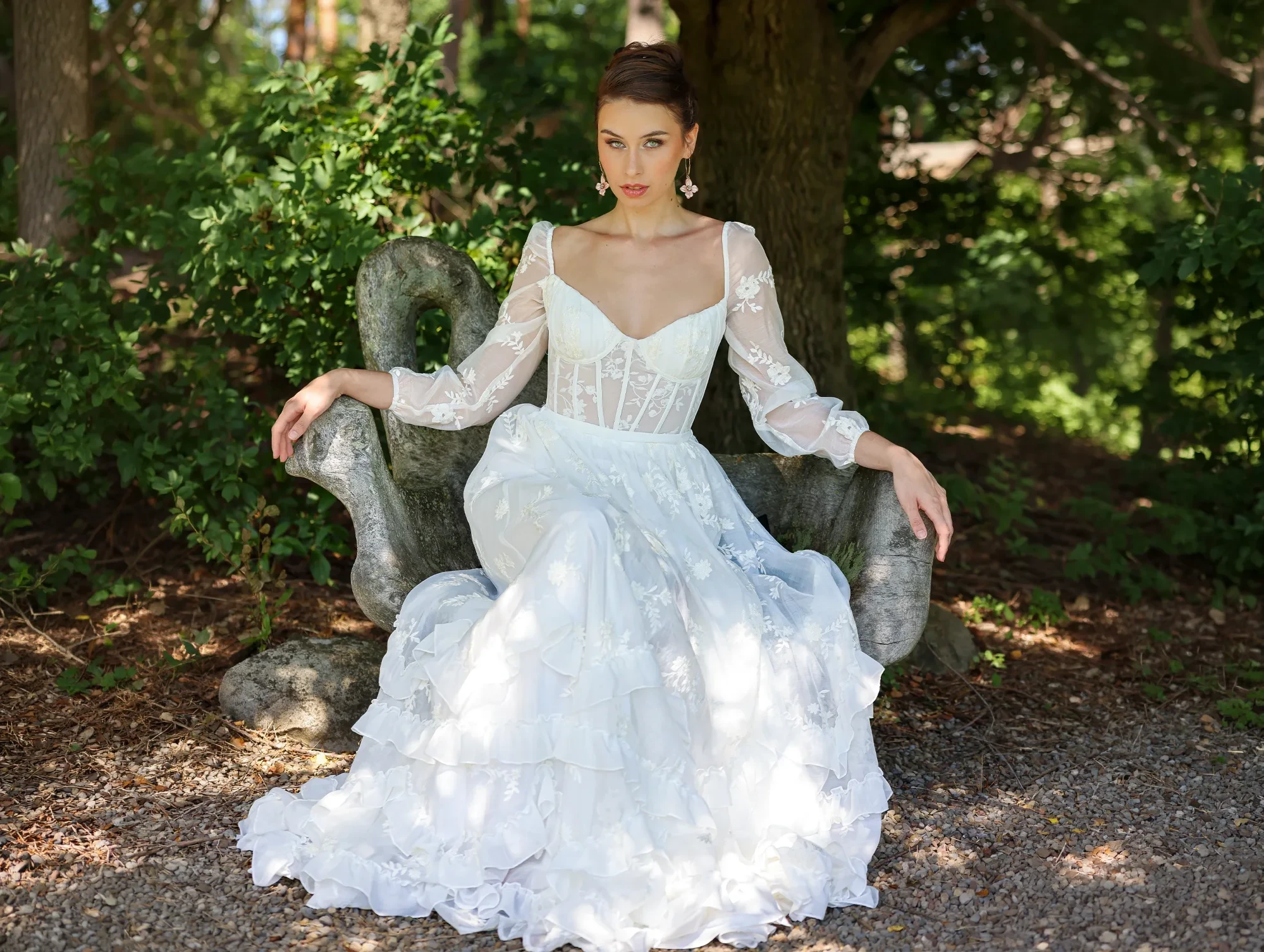 Model wearing a bridal dress on the forest.